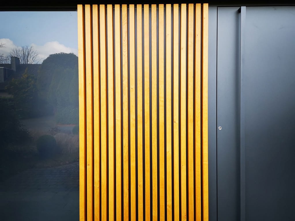 Eine Haustür aus schwarzem Aluminium mit Holz Verkleidung und schwarzem Glas