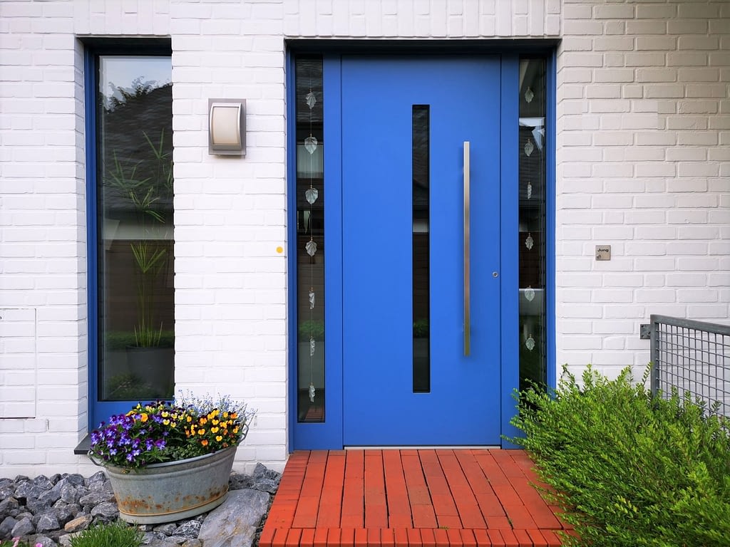 Blaue Haustür in weißer Klinkerfassade