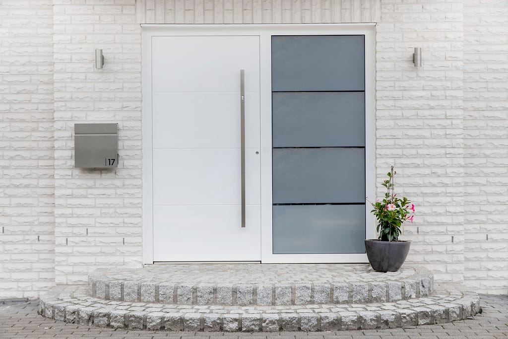 Weißer Klonker kombiniert mit moderner, weißer Haustür