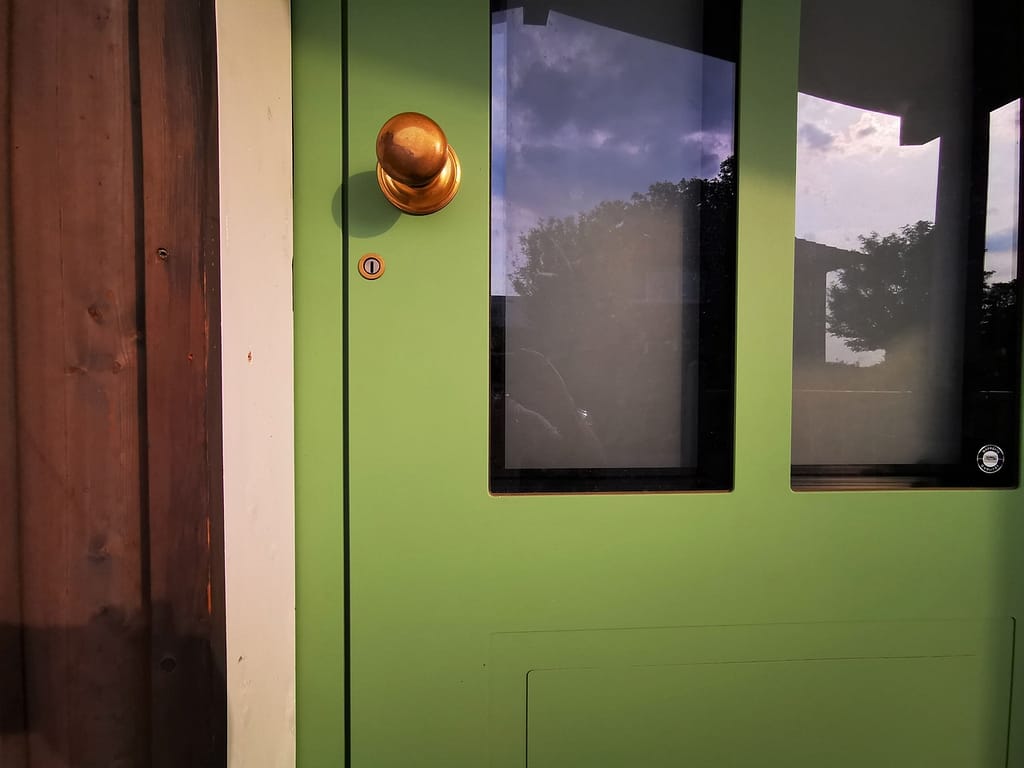 Haustürgriff Knauf aus Messing in grüner Haustür